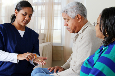 caregiver gives medicine to a senior man