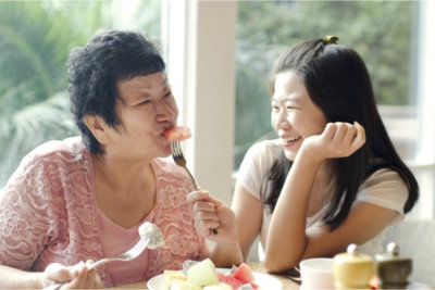 mother and daughter happily eating together 